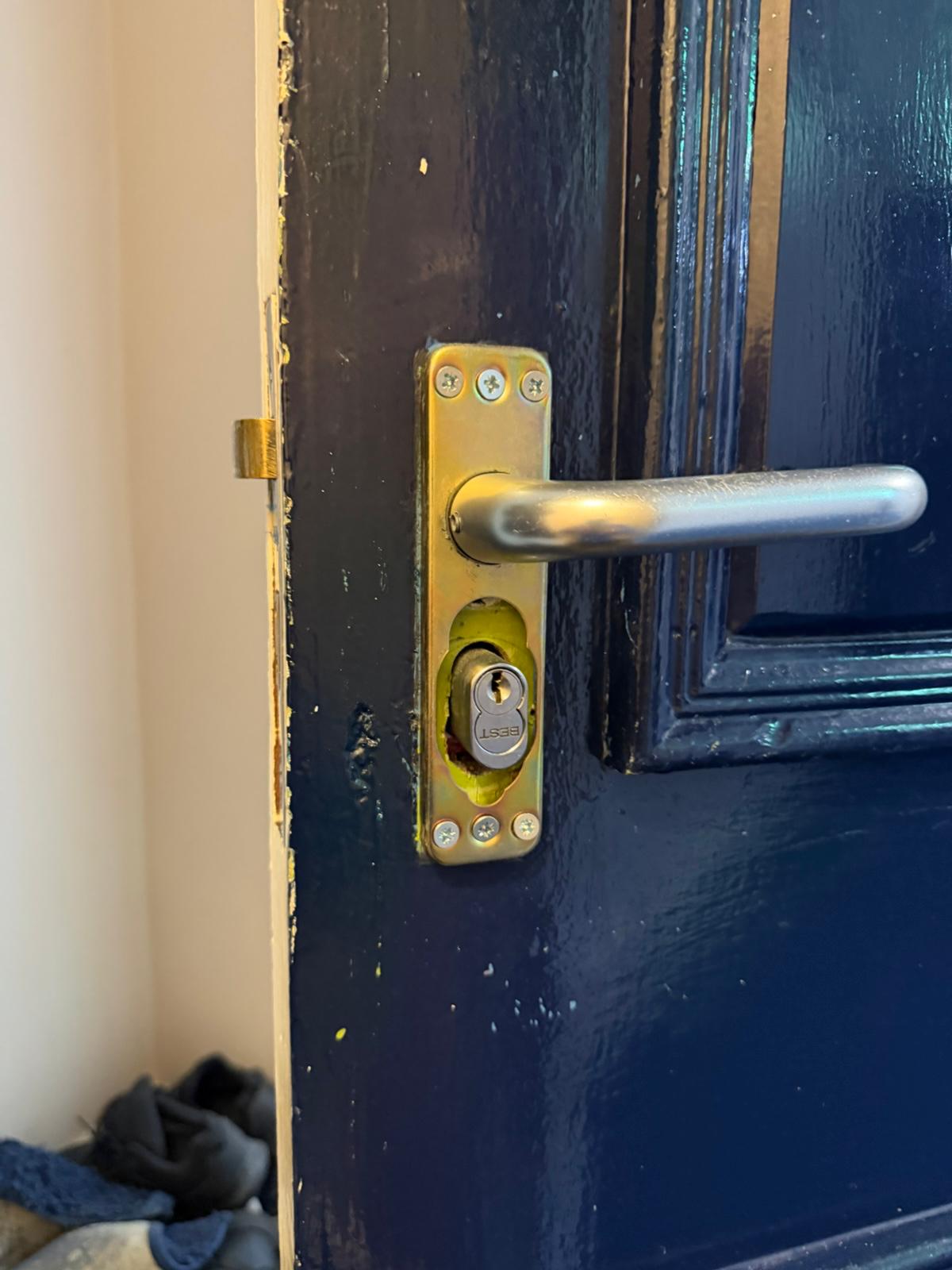 Dark blue painted door fitted with brushed steel lever handle and new anti-snap cylinder
