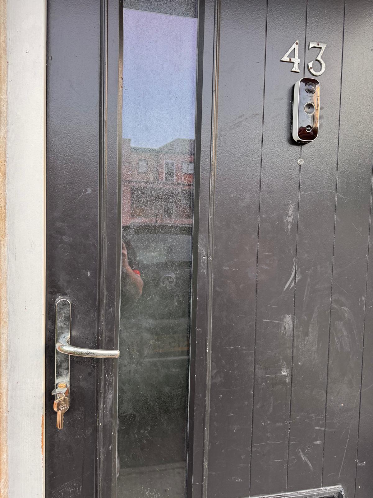 Grey composite front door with chrome handle and smart video doorbell installed